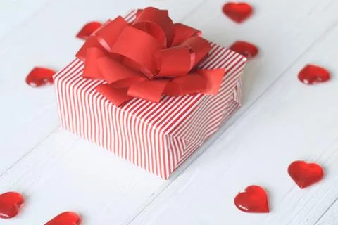 Gift box with red bow and hearts on light background Stock Photos