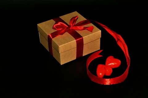 Gift box with red bow and aroma candles isolated on a black background. Space Stock-Fotos