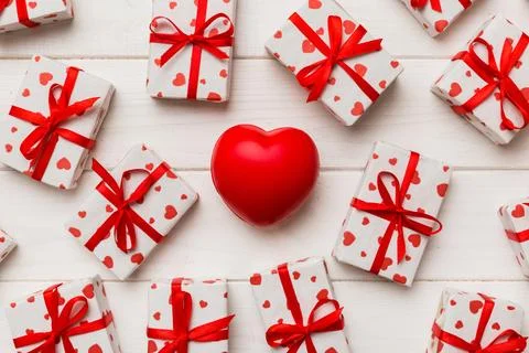 Gift box with red bow and red heart on colored background . Top view. Flat la Stock Photos