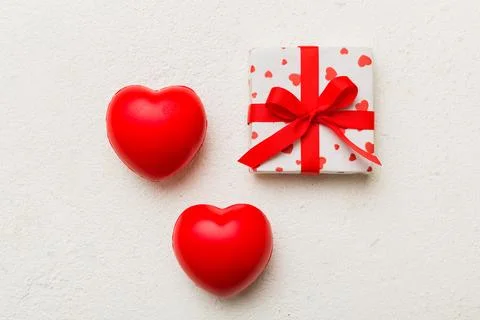 Gift box with red bow and red heart on colored background . Top view. Flat la Stock Photos