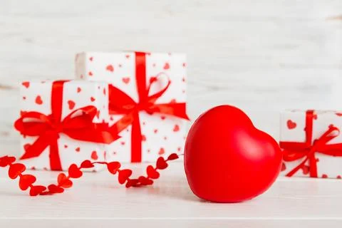 Gift box with red bow and red heart on colored background. Perspective view.  Stock Photos