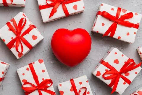 Gift box with red bow and red heart on colored background . Top view. Flat la Stock Photos