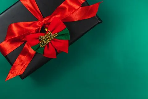 Gift box with red bow and Merry Christmas, on green background Stock Photos