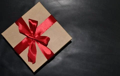 Gift box with red bow on a dark background. Space for text Foto stock