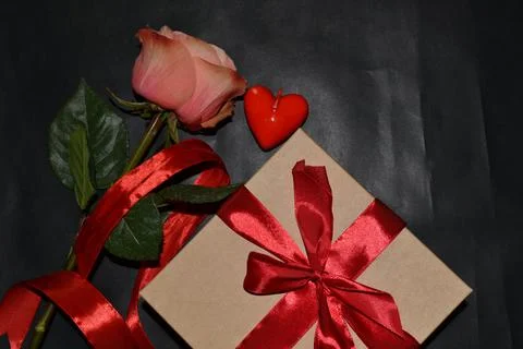 Gift box with red bow, pink rose and aroma candles on a dark background. Top  스톡 사진