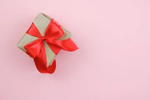Gift box with a red bow on a pink background. The concept of celebrating diff Stock Photos