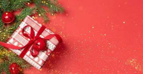 Gift box red bow spruce branches red background. New Year or Christmas banner Stock Photos