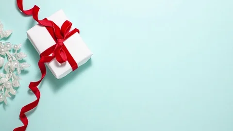 Gift box red ribbon bow on blue flat lay copy space Stock Footage