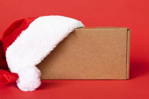 Gift box with red santa hat on red background. present for Christmas, new year Stock Photos