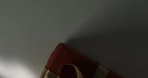 Gift Box with Red Wrapping and Gold Ribbon in Sunlight Stock Footage 295144363