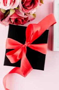 Gift box, roses and empty frame on a pink background Stockfoto's