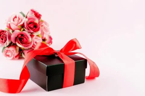 Gift box, roses and empty frame on a pink background Stock Photos