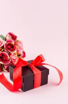 Gift box, roses and empty frame on a pink background Stock Photos