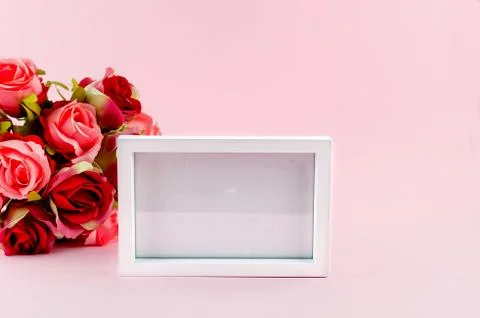 Gift box, roses and empty frame on a pink background 스톡 사진