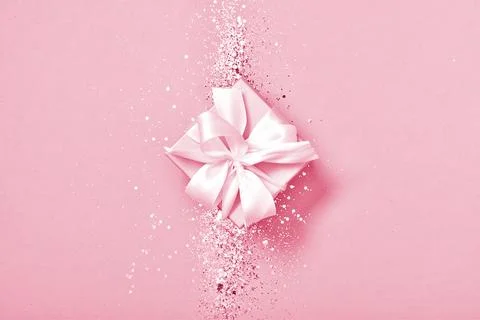 A gift box with sequins on a purple background. Minimalism. Stock Photos