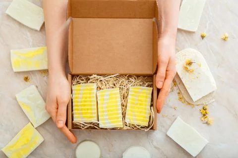 Gift box with set of natural soap in female hands. DIY soaps kit. Many variou Stock Photos