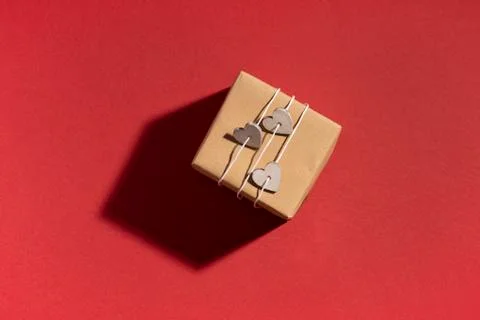 Gift box with shadow on red surface. Top view, flat lay Stock Photos