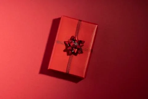 Gift box with shadow on red surface. Top view, flat lay Stock Photos