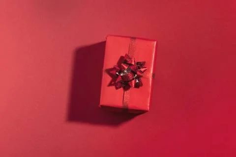 Gift box with shadow on red surface. Top view, flat lay Stock Photos