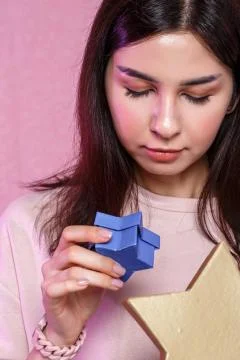 Gift box in the shape of a gold star in the hands of a young Asian girl. on a Stock Photos