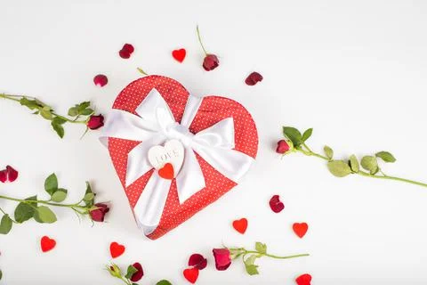Gift box shape of a heart with bow isolated on white background with red rose Stock Photos
