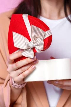 Gift box in the shape of a heart in the hands of a young Asian girl. on a pin Stock Photos
