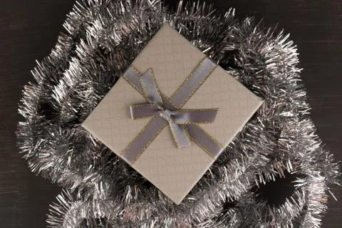 Gift box with silver tinsel Stock Photos
