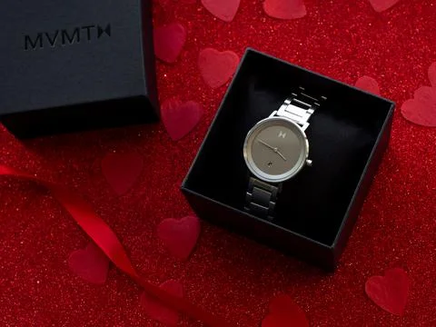 Gift box with silver watch is on red heart paper background Stock Photos