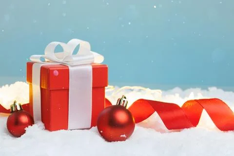 Gift box on snow with two baubles, copy space Stock Photos