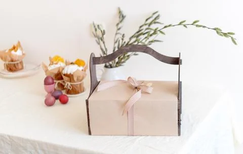 Gift box with spring flowers on light natural fabric background. Easter baske Stock Photos