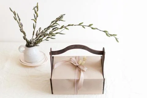 Gift box with spring flowers on light natural fabric background. Easter baske Stock Photos