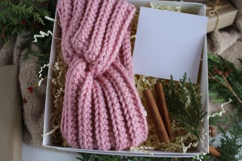 The gift box is on the table. There is a knitted bandage in the box. Gifts for Stock Photos