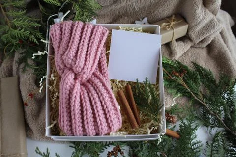 The gift box is on the table. There is a knitted bandage in the box. Gifts for Stock Photos