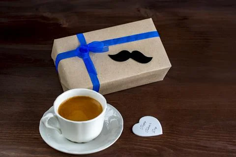 Gift box with a tag and a cup of coffee Stock Photos