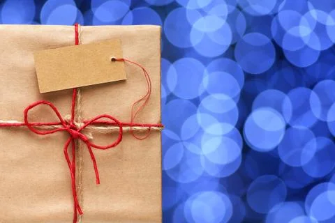 Gift box with tag on background of blurred blue lights 스톡 사진