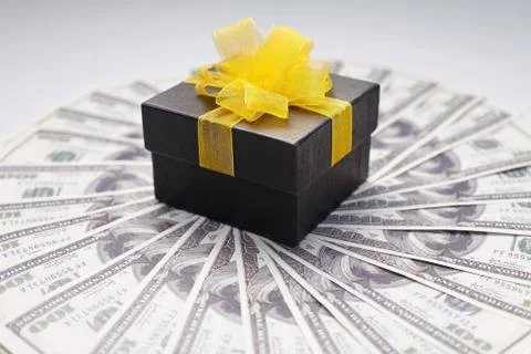 Gift box on top of banknotes Stock Photos