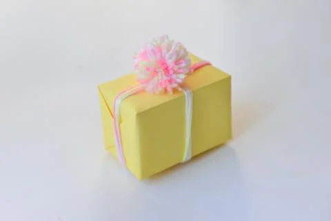 Gift box on a white background. winter holidays, pompom from threads, warm Stock Photos
