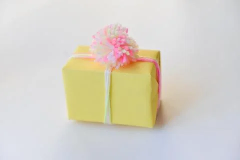 Gift box on a white background. winter holidays, pompom from threads, warm Stock Photos