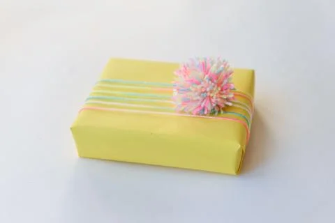 Gift box on a white background. winter holidays, pompom from threads, warm Stock Photos