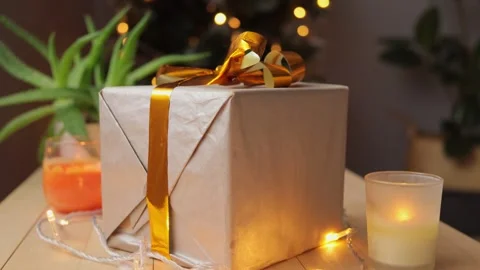 Gift box on wood table with lights and candles with Christmas tree bokeh Vídeos de archivo 255109433
