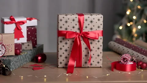 Gift box wrapped in kraft paper standing on background of christmas tree Stock Footage 165180249
