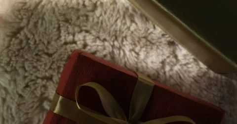 Gift Box Wrapped in Red Paper with Golden Ribbon on Soft Background Stock Footage 295143641