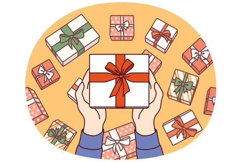 Gift box wrapped in red ribbon and bow in hands, demonstrating packaging o... Stock Photos