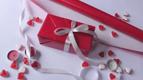 Gift box wrapping in a red paper with white ribbon bow on the white background Stock Footage 231309387