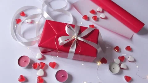 Gift box wrapping in a red paper with white ribbon bow on the white background Stock Footage 231370307