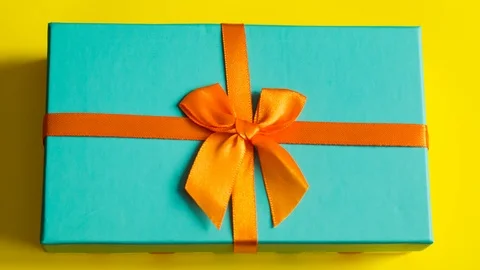 Gift box on yellow background top view close up stop motion Stock Footage 102281793