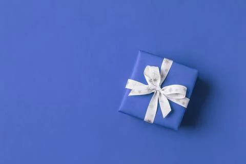 Gift boxe with white bow on a blue backdrop. Stock Photos
