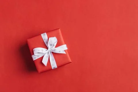Gift boxe with white bow on a red backdrop. Stock Photos