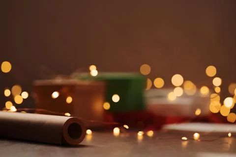 Gift boxes and festive packaging with christmas light on a table closeup Stock Photos