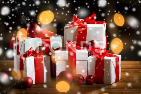 Gift boxes and red christmas balls on wooden floor Stock Photos